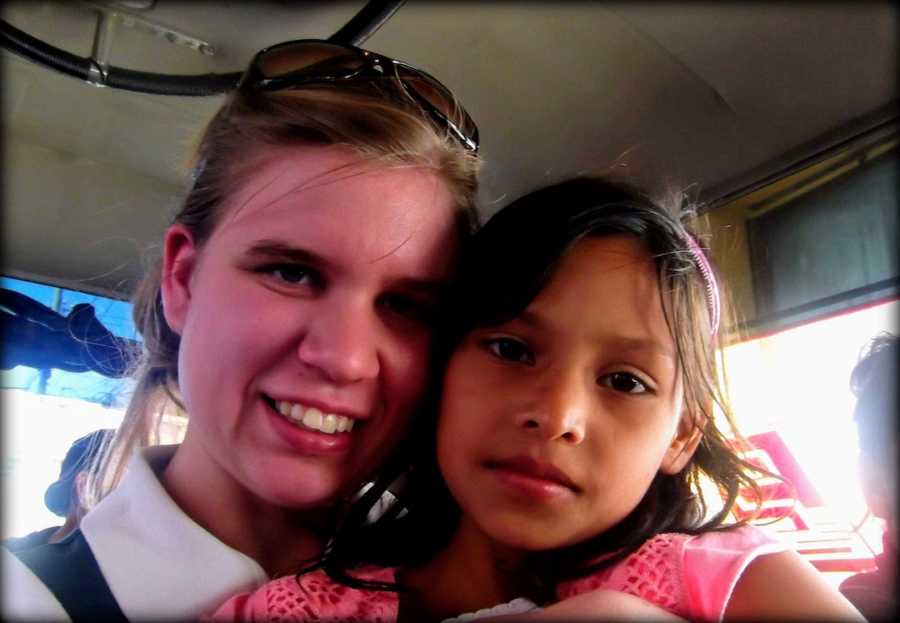 Teenage girl with young girl smiling in car