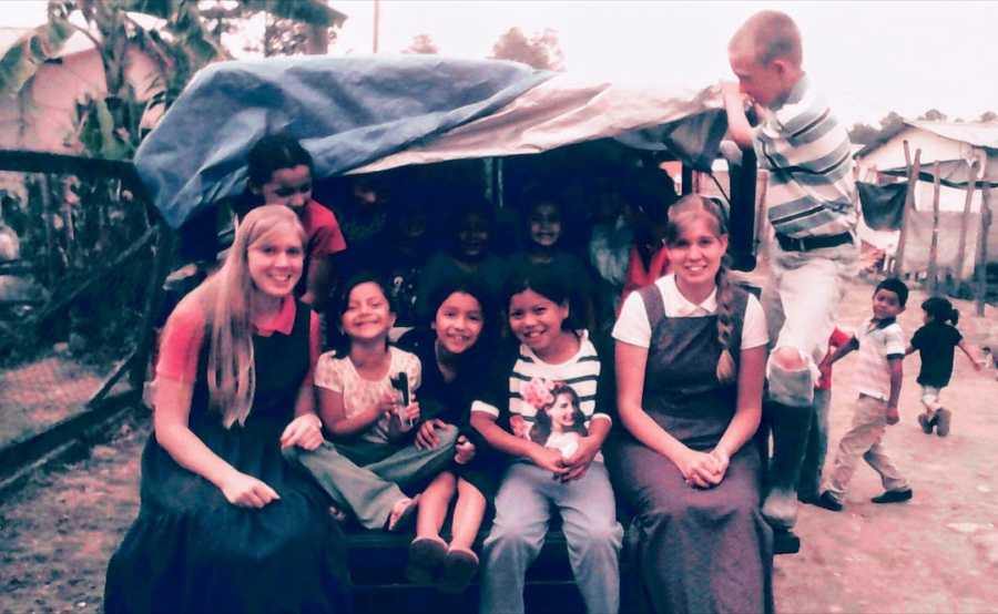 Group of people sitting in back of truck outside