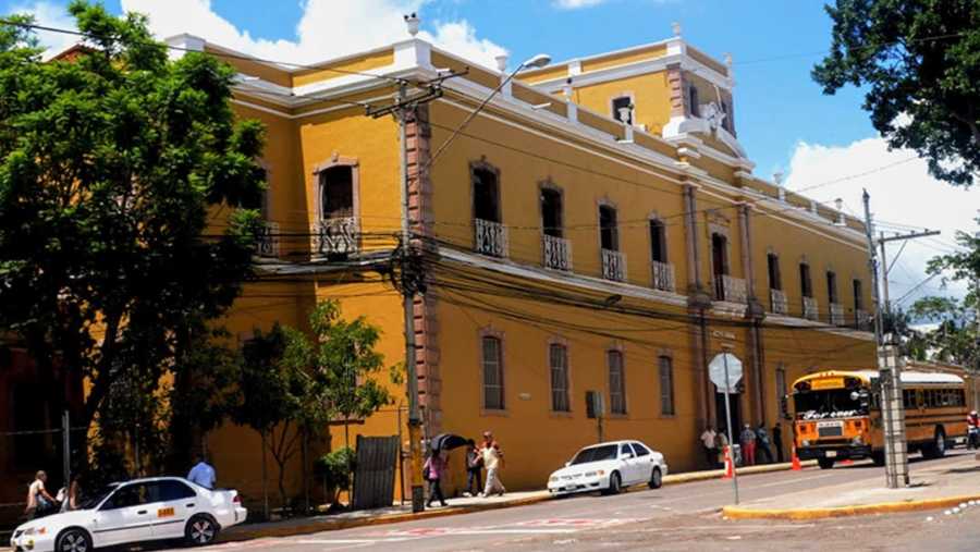 Two story yellow building with bus on street