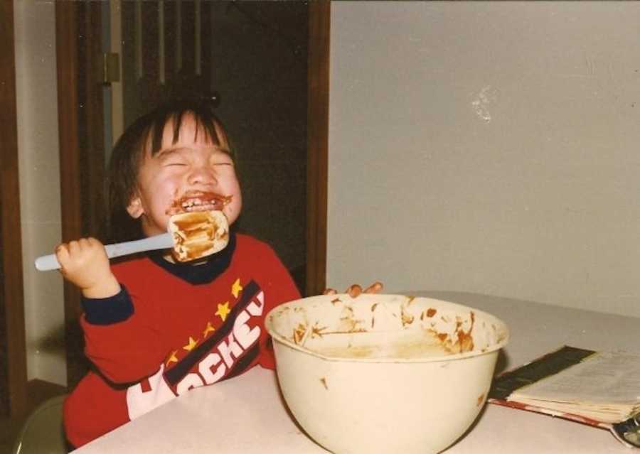 young boy licking spatula