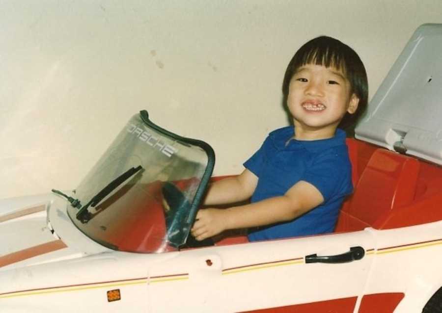 young boy in toy car