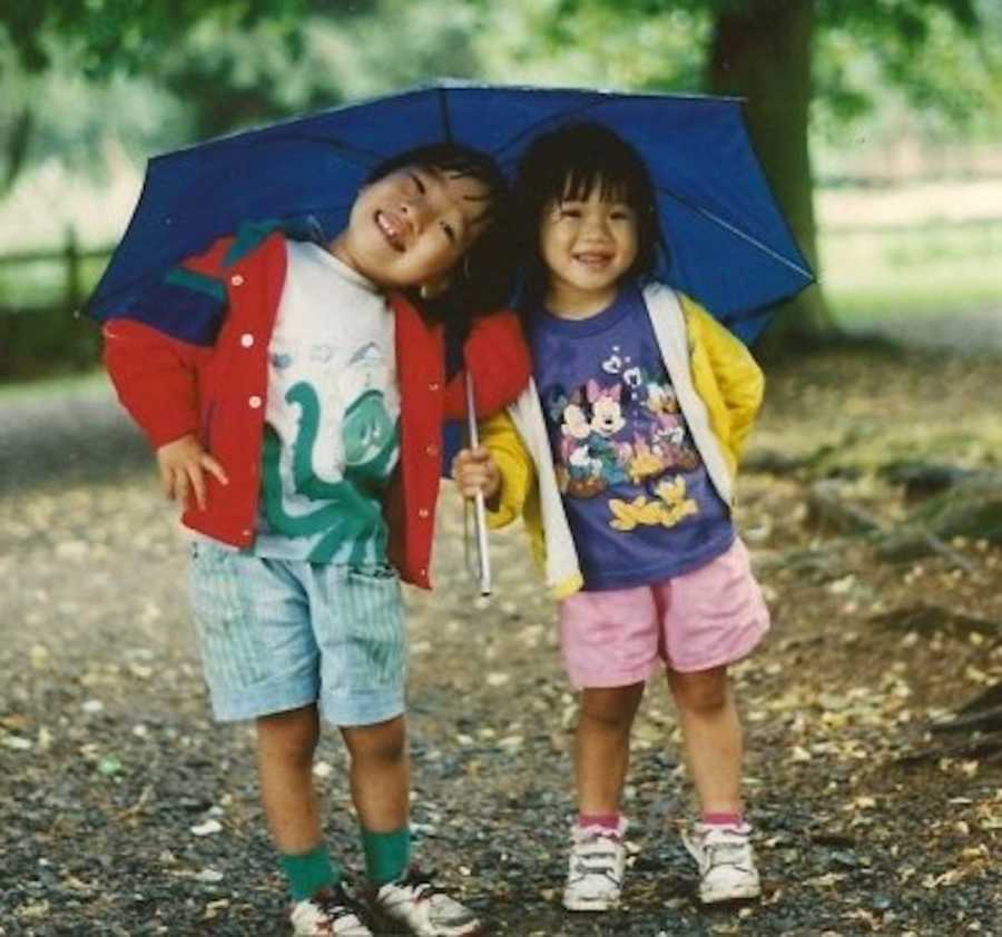 two siblings under an umbrella