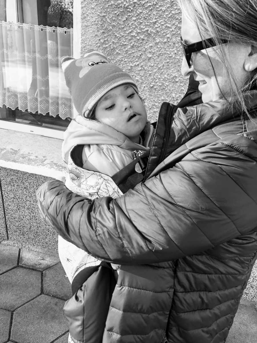 An adoptive mother holds her daughter with Down Syndrome