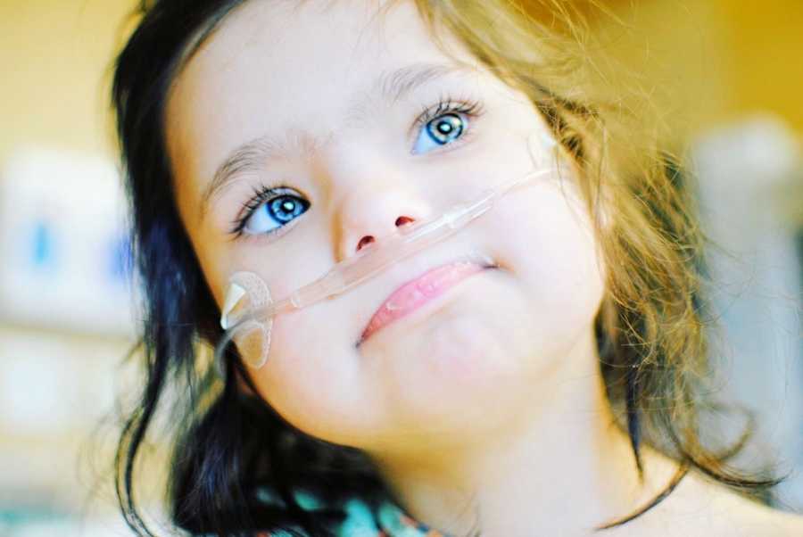 A girl with special needs wearing an oxygen tube