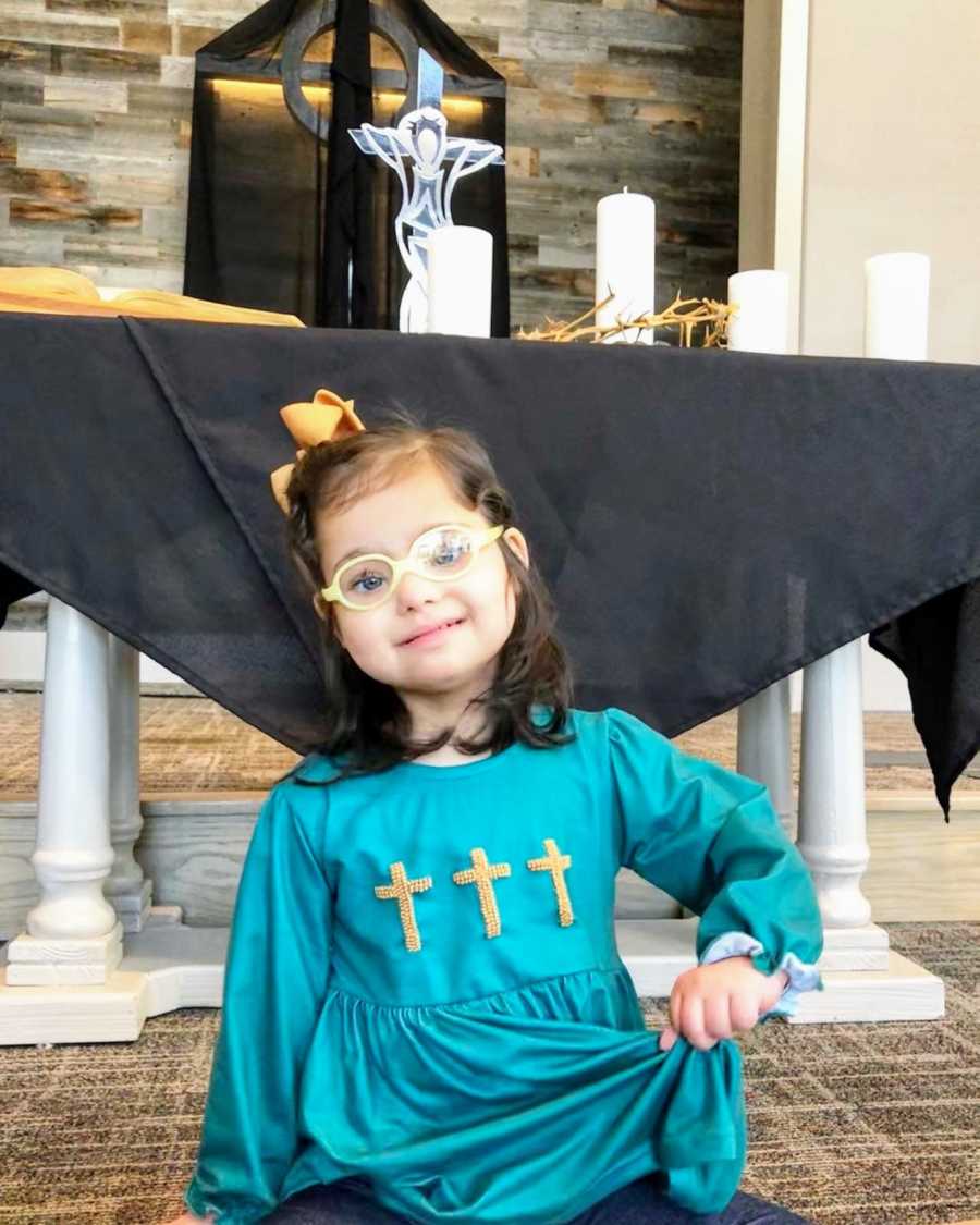 A girl with Down Syndrome wearing a blue dress