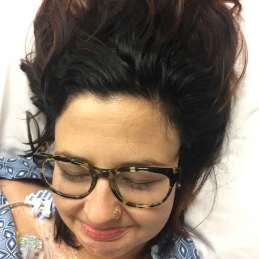 Woman in hospital bed upset wearing glasses