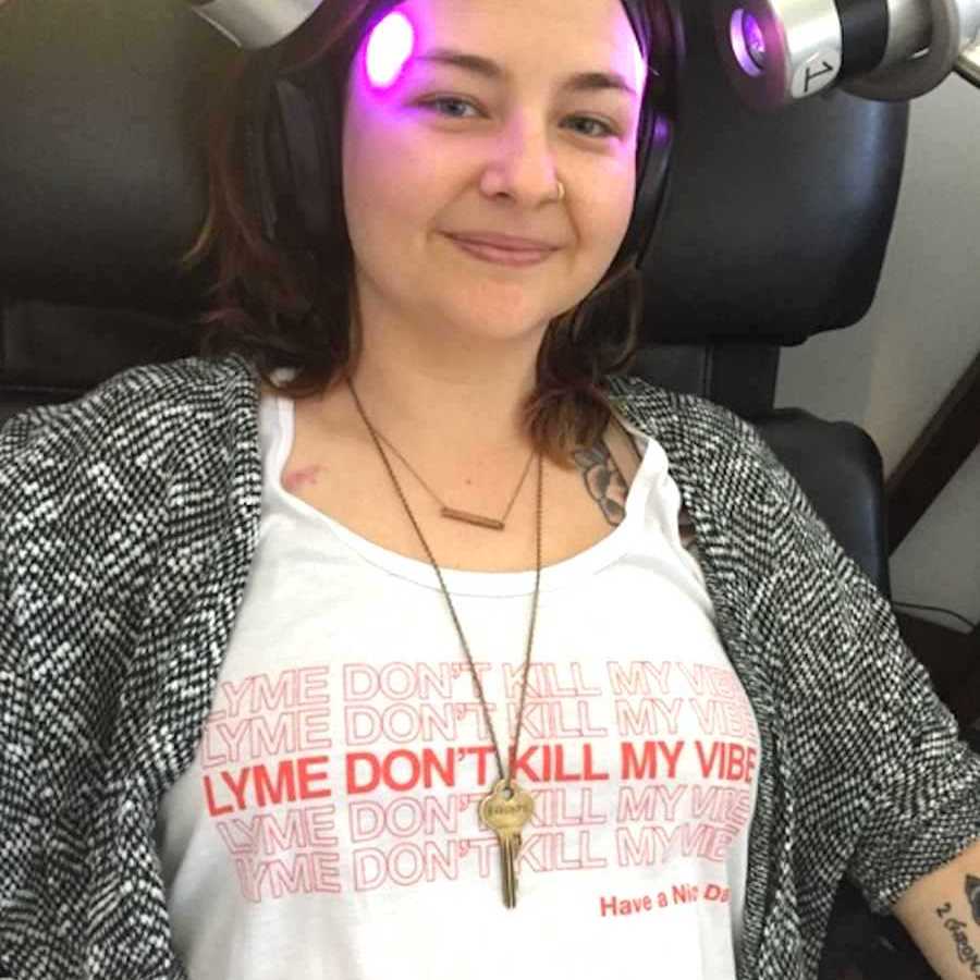 Woman sitting in a chair with two purple lights shining on her head