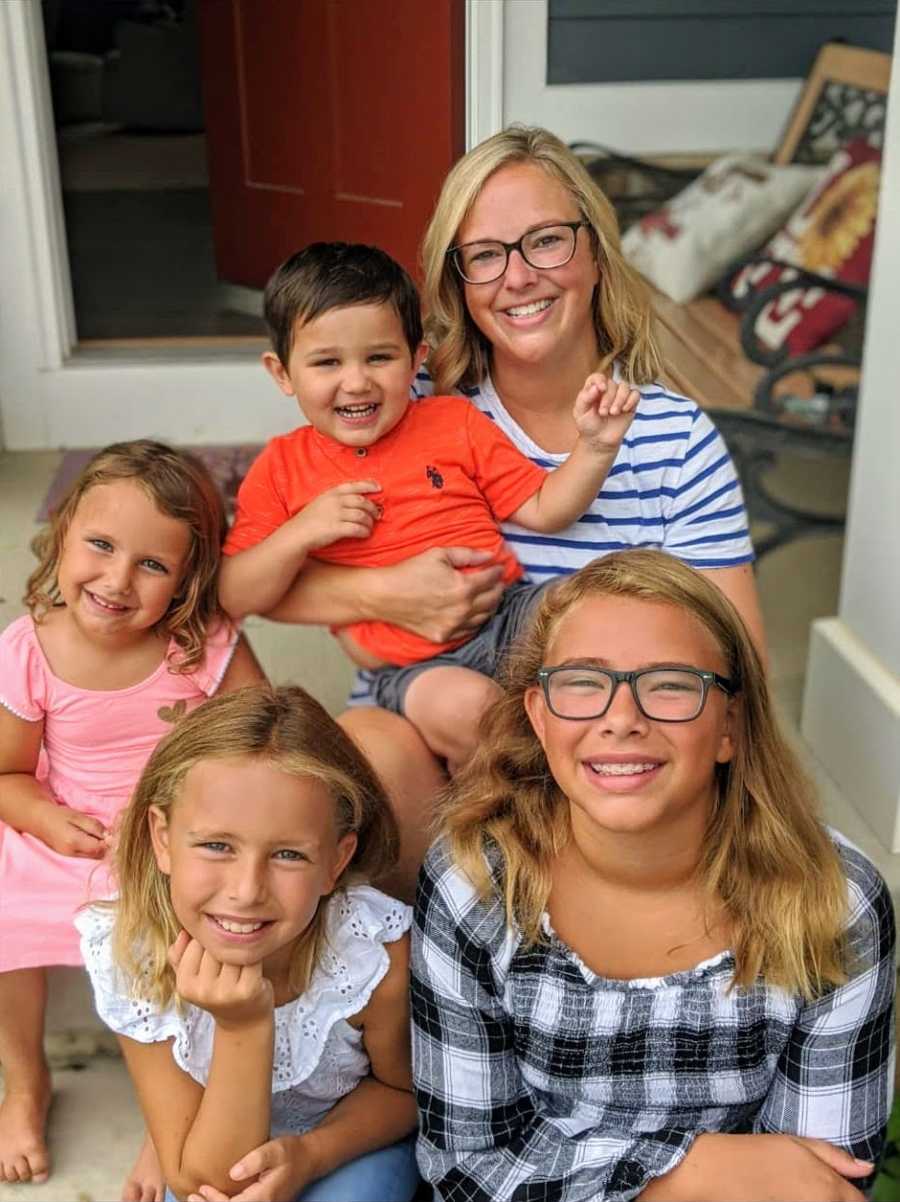 foster family posing with foster son, smiling on porch