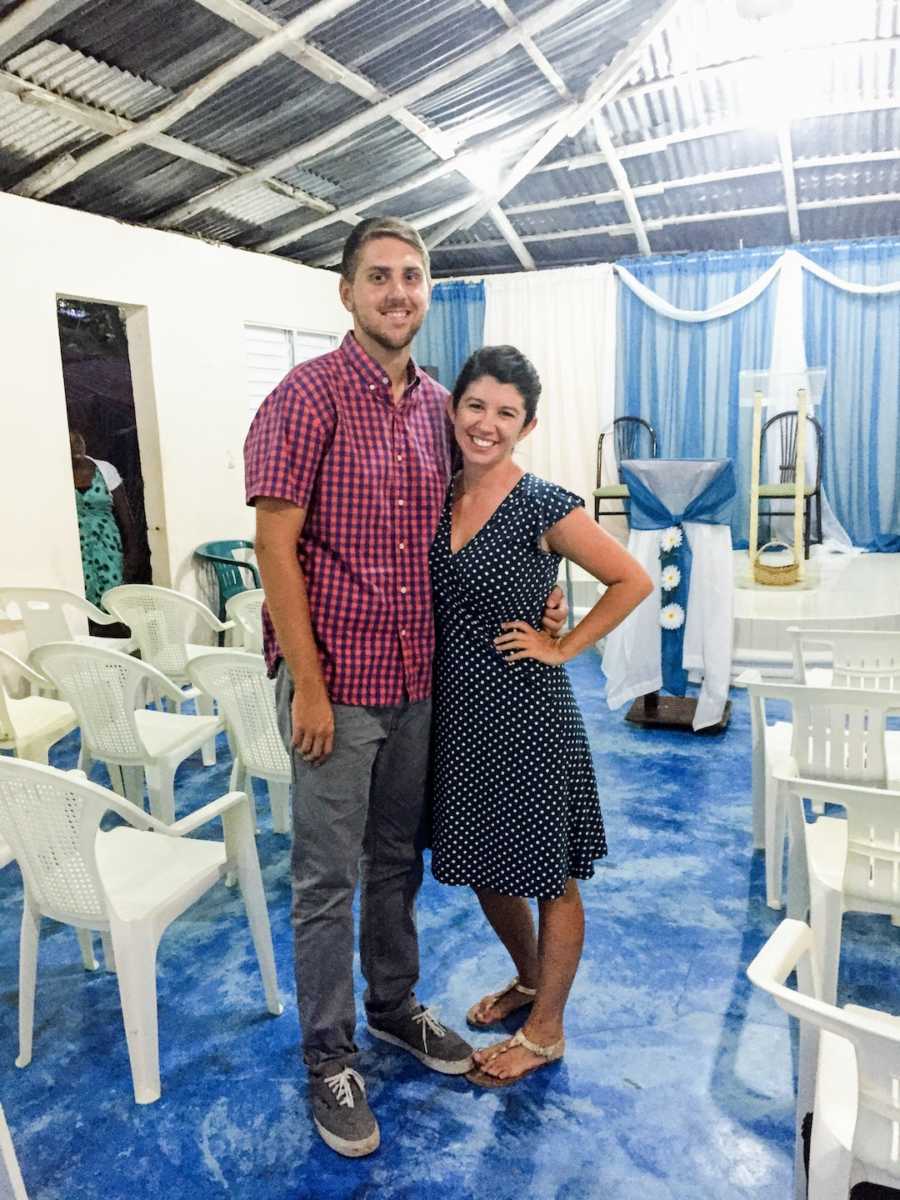 A couple poses with arms around each other at a wedding