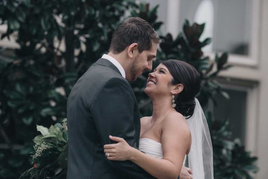 A newlywed husband and wife look into each other's eyes and smile