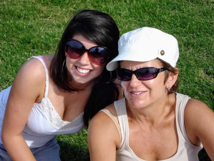 A mother and daughter wearing sunglasses smile