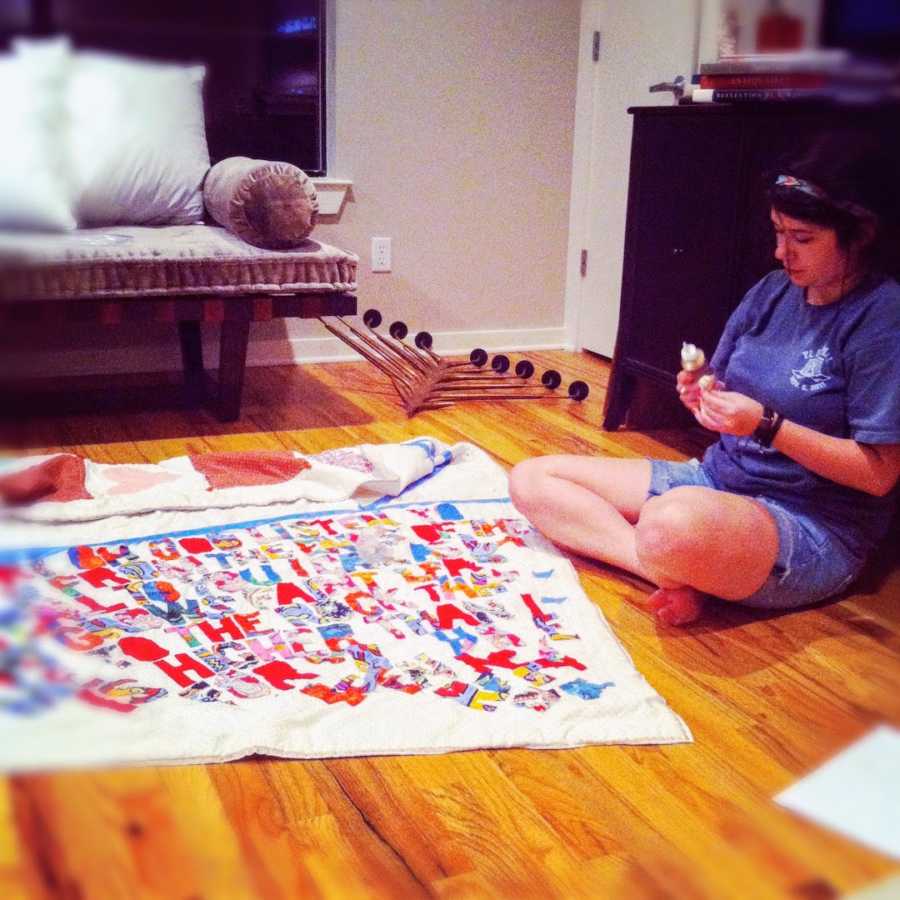 A woman crafts a quilt while sitting on the floor