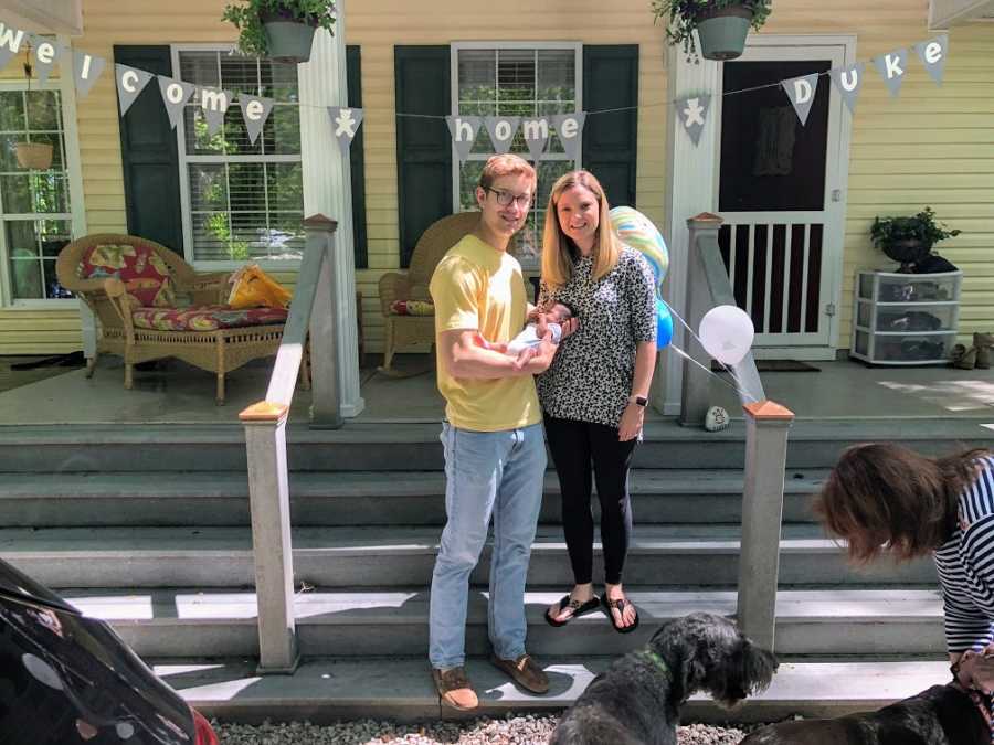 Adoptive parents hold their son at his welcome home party