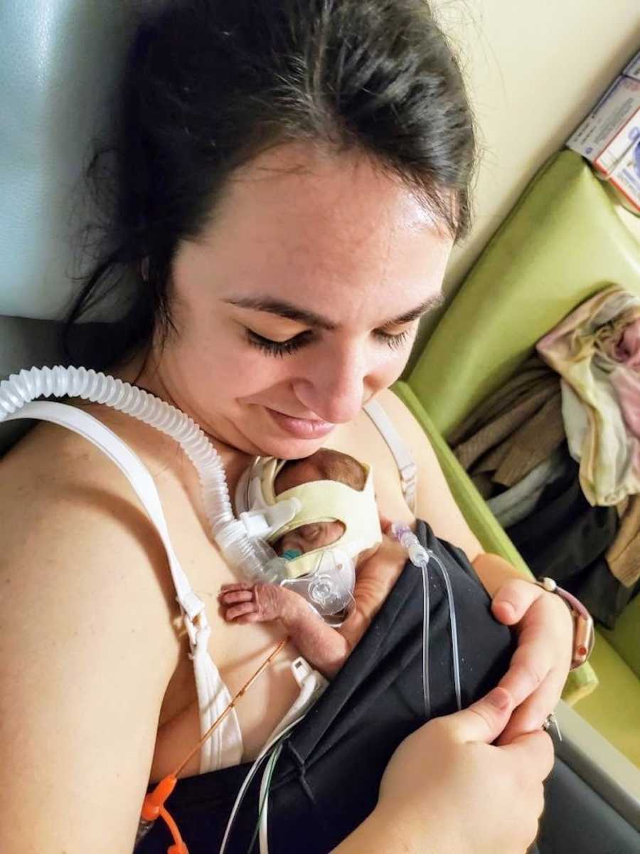 New mom looking down at baby wearing oxygen mask