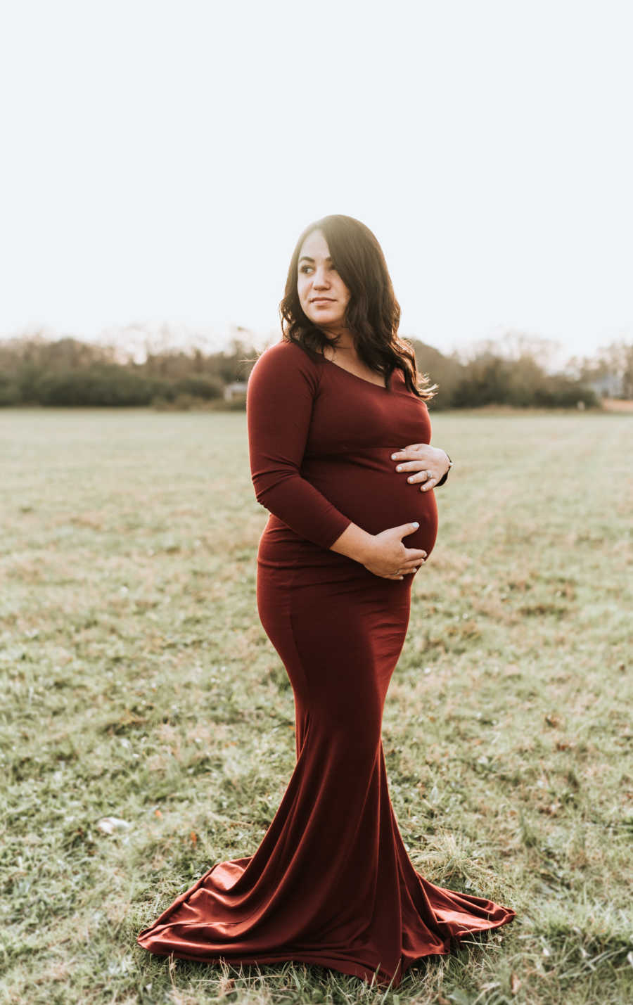 Maternity photoshoot of a woman standing in a field