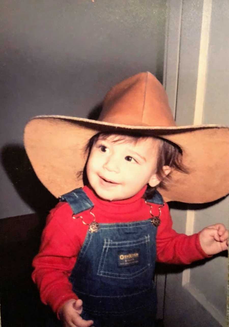 Toddler wearing cowboy hat and overalls