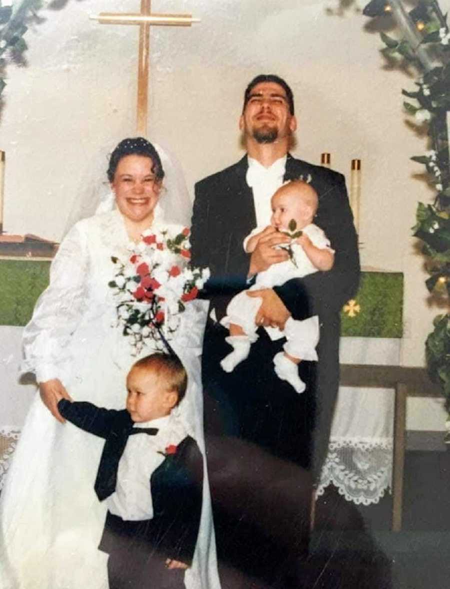 A bride with her children and her new husband in a wedding dress