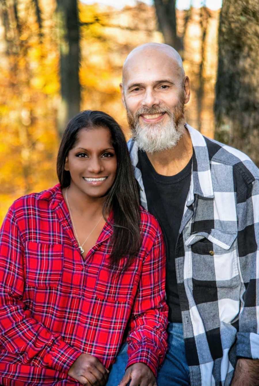 An adoptee and her partner in front of trees in the fall