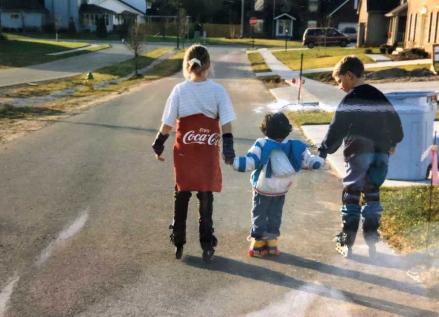 A pair of siblings teach their adopted sister how to roller blade