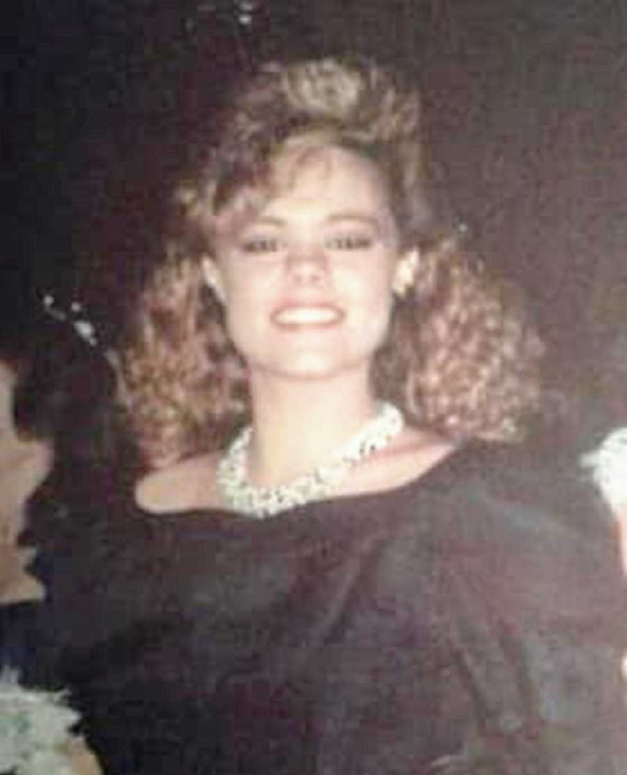 A teenager with curly hair wearing a black dress