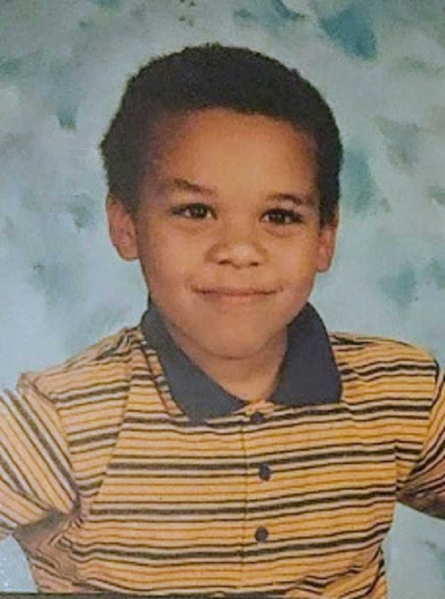 A mixed race adopted boy wearing a yellow collared shirt