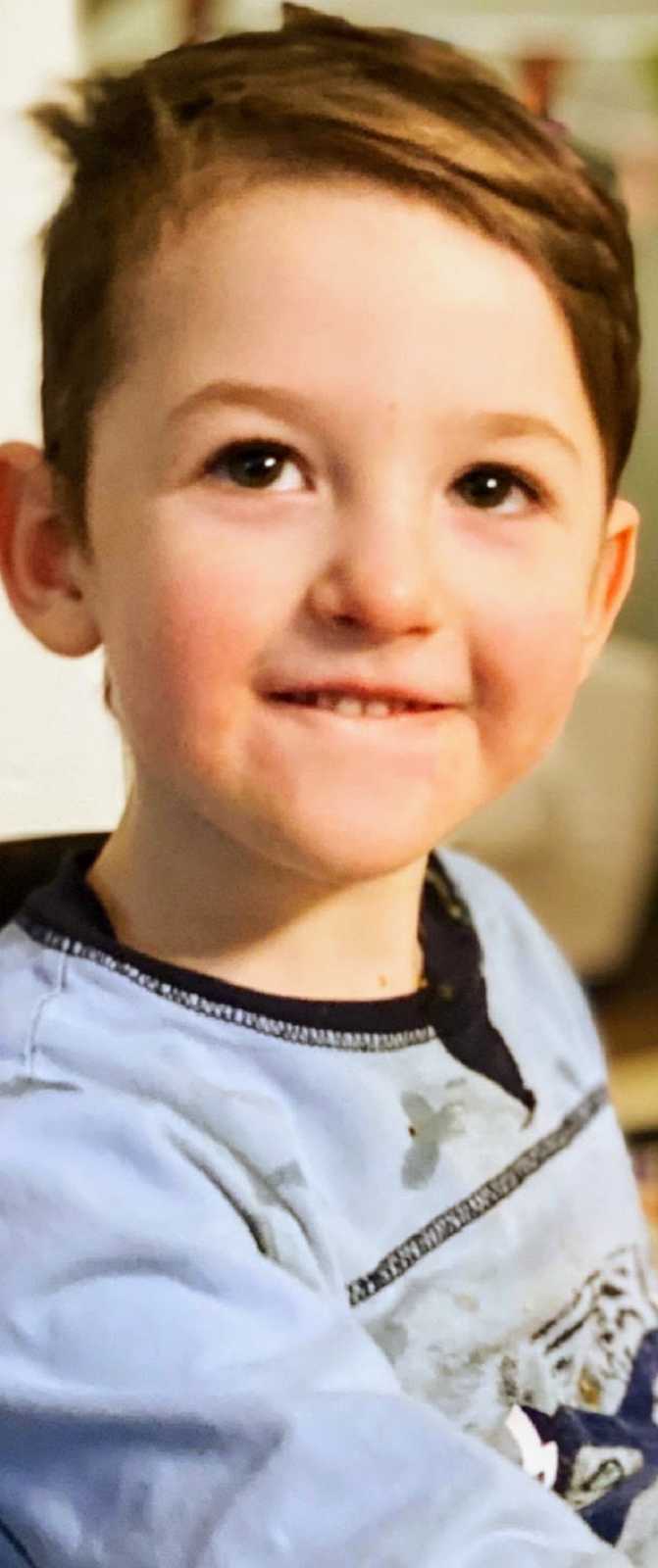 A boy with special needs wearing a blue shirt