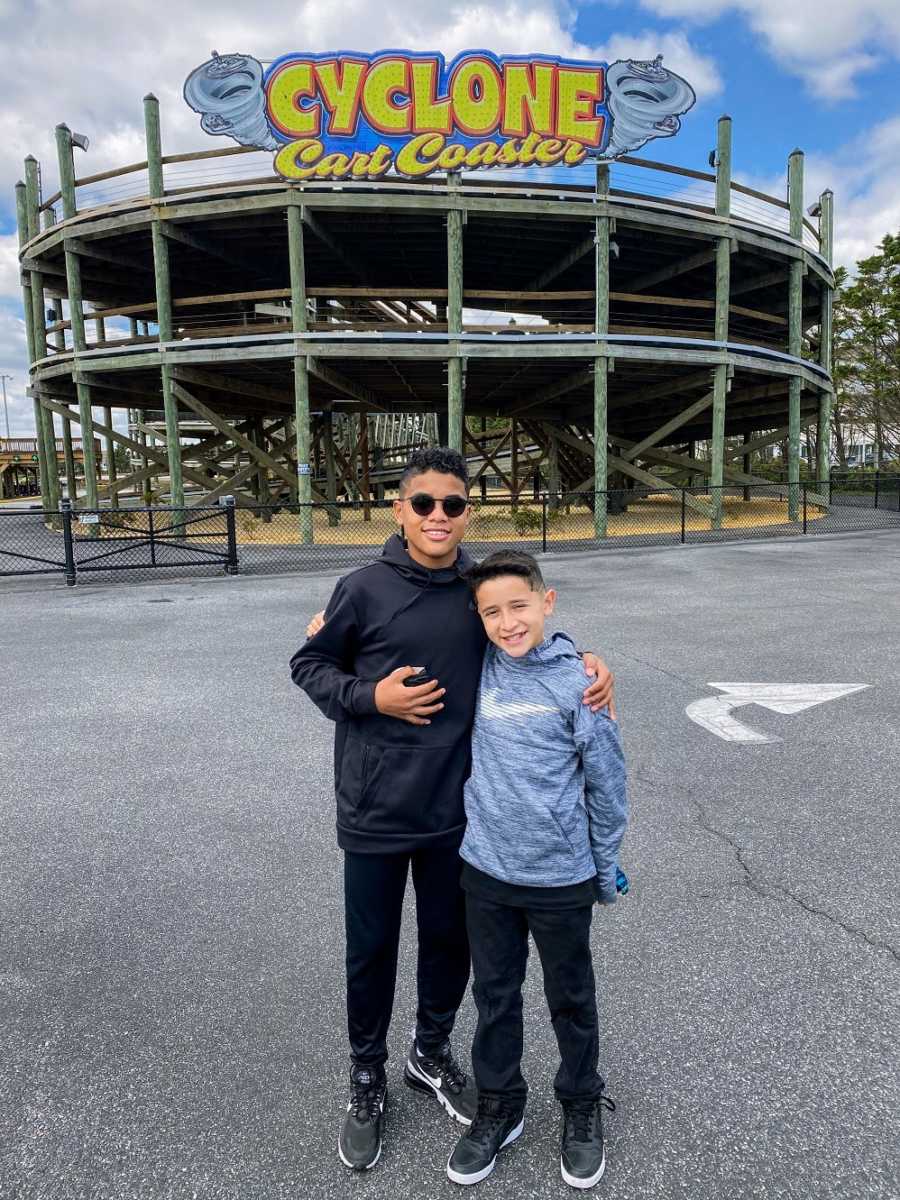 A pair of brothers stand outside a rollercoaster