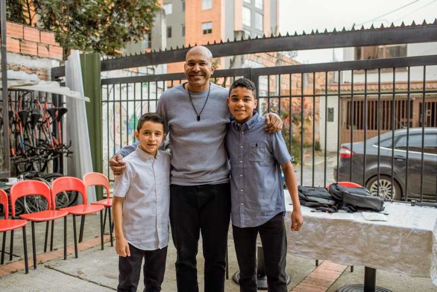 A single adoptive father and his sons stand together for a family photo