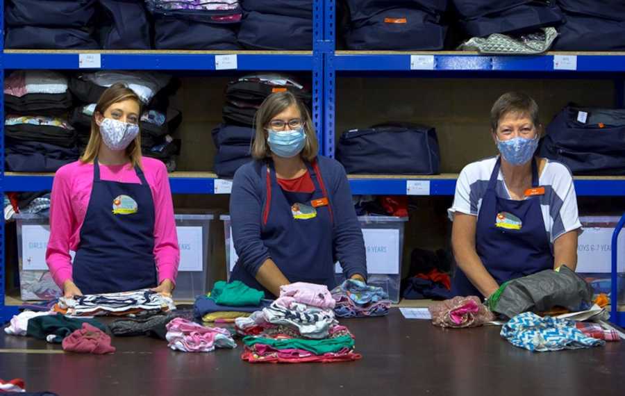 3 women smiling as they work