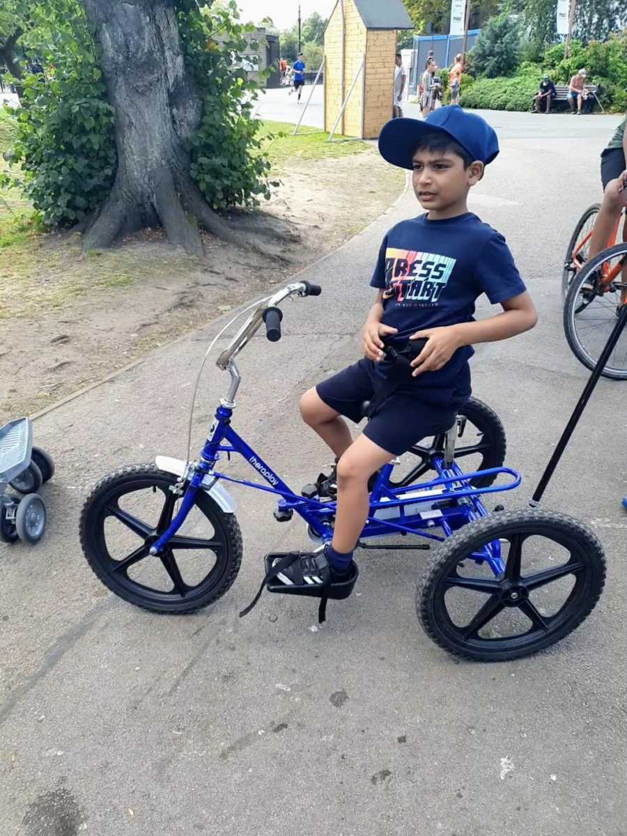 A boy with nonverbal autism on a three-wheeled bike