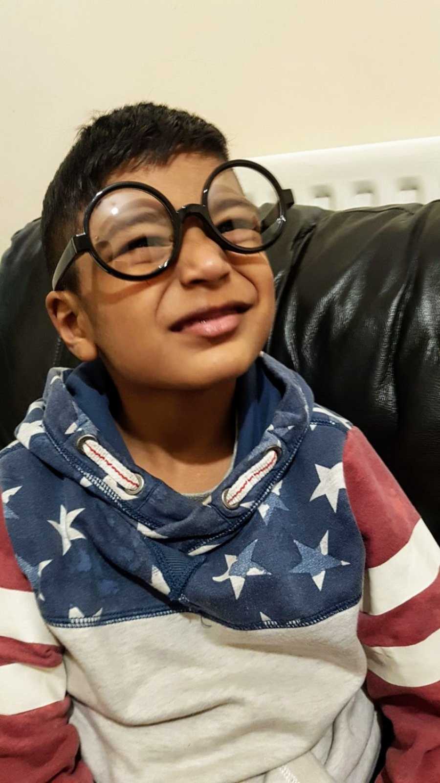 A boy with nonverbal autism wearing large glasses