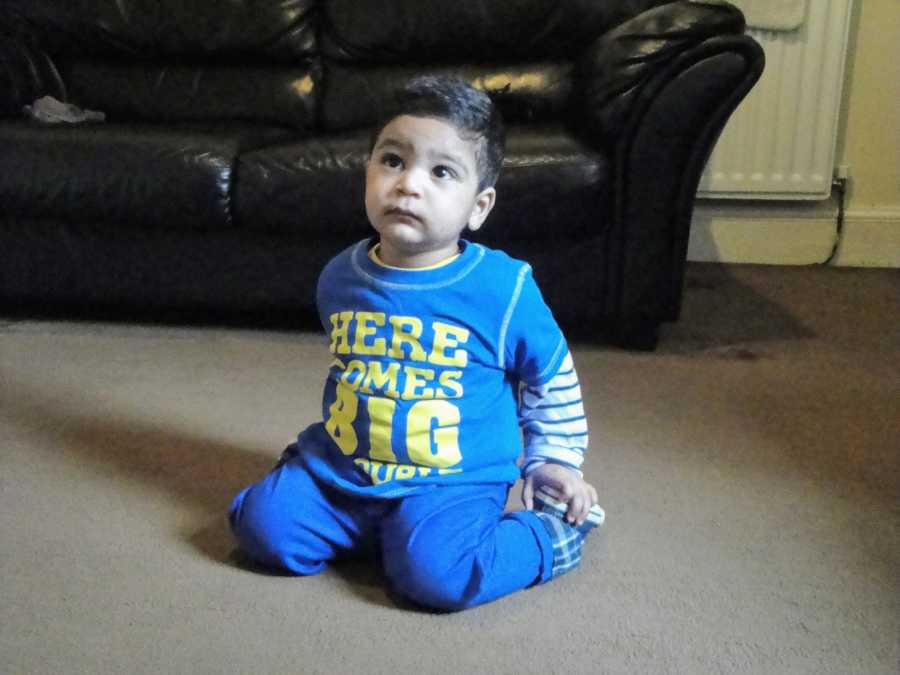 A toddler with nonverbal autism sits on the floor