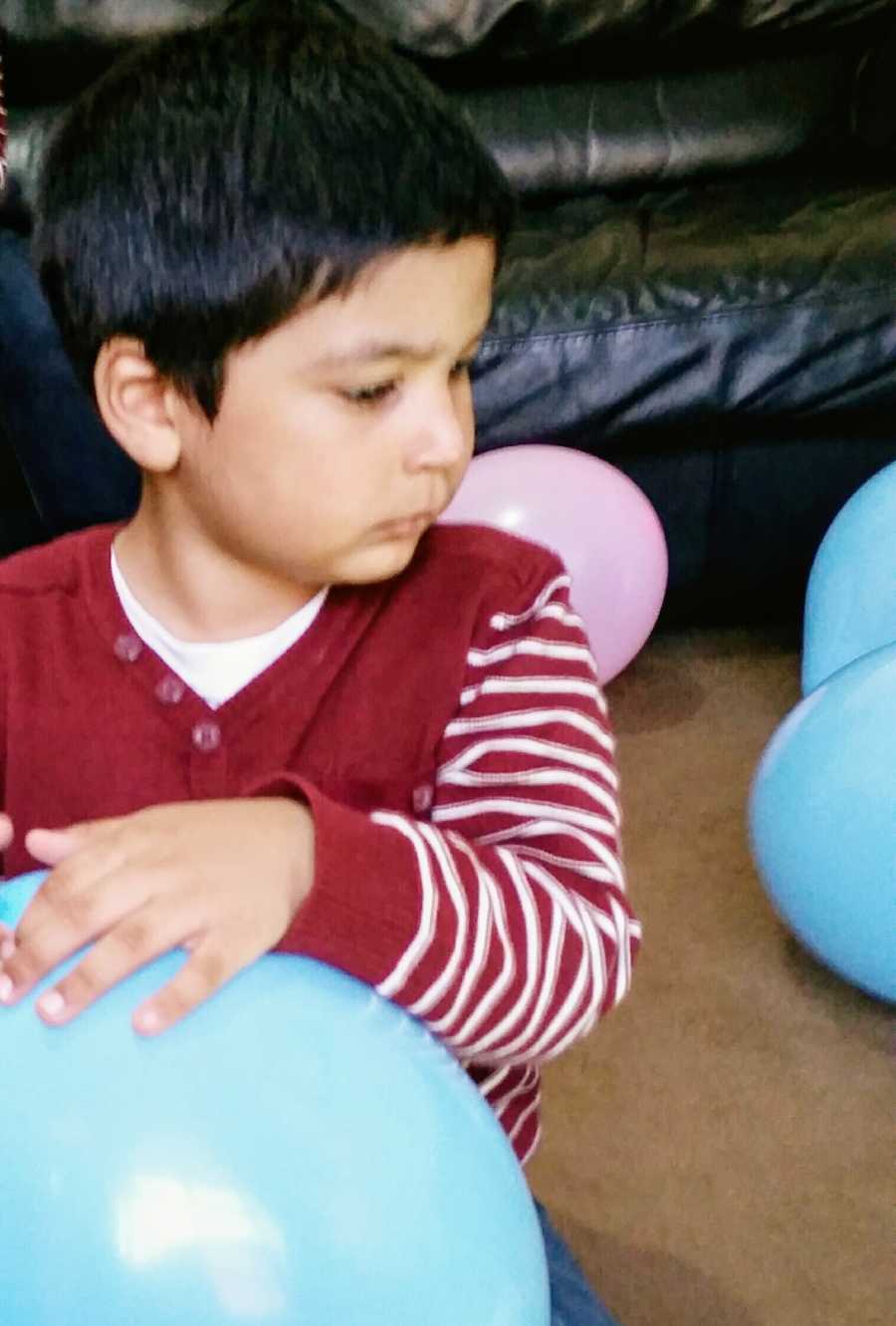 A toddler with nonverbal autism holds a balloon