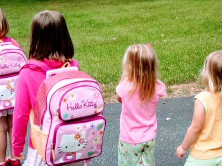 Mom snaps a photo of her four daughters as they walk to the bus stop for school
