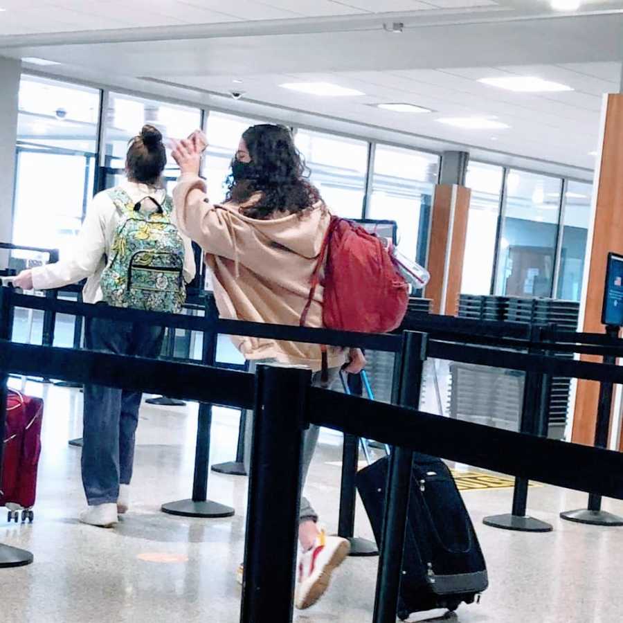 Mom snaps photo as her daughter waves and leaves in the airport