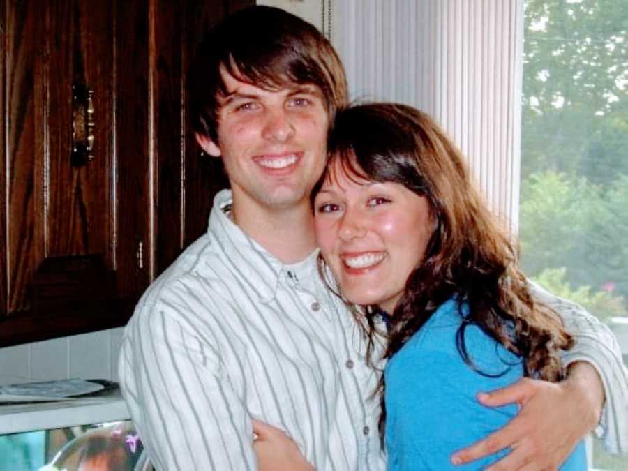 Young married couple share a sweet embrace in their kitchen