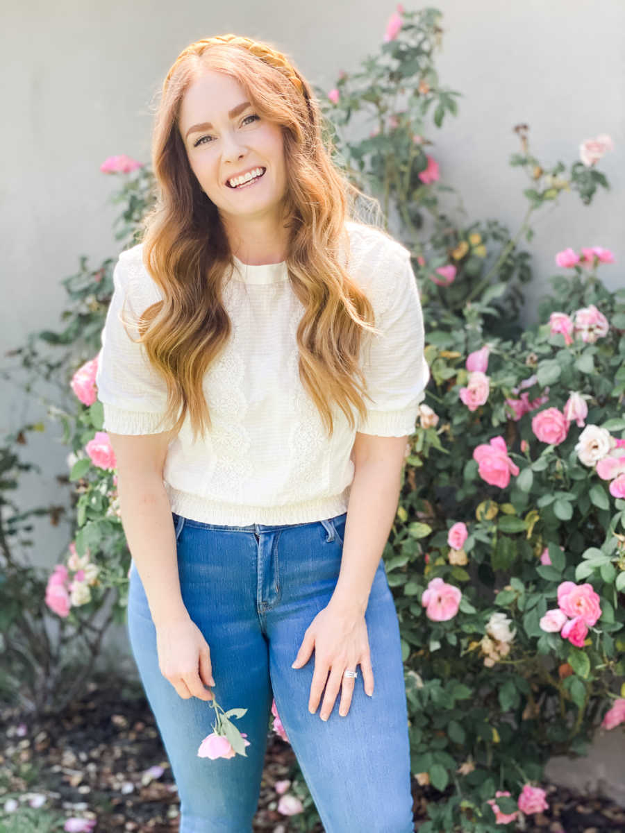 woman smiling outside with flowers