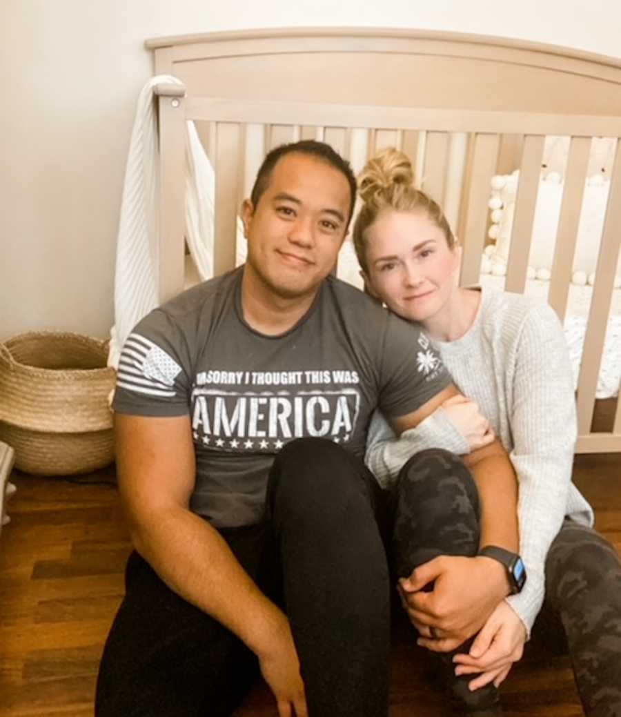 couple posing in front of crib