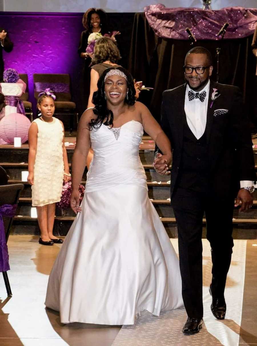 Couple walk hand-in-hand to the dance floor during their wedding reception