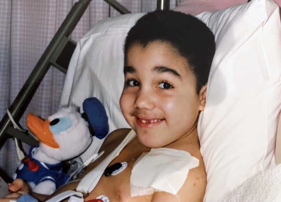 Young boy in hospital bed with Donald Duck stuffed animal