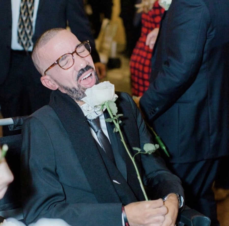 Man at wedding using flower as microphone