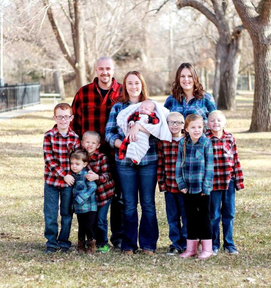Beautiful blended family with seven children take family photos in red and blue plaid shirts