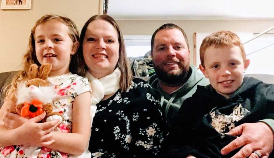 Family of four take a selfie together while spending some down time together on the couch