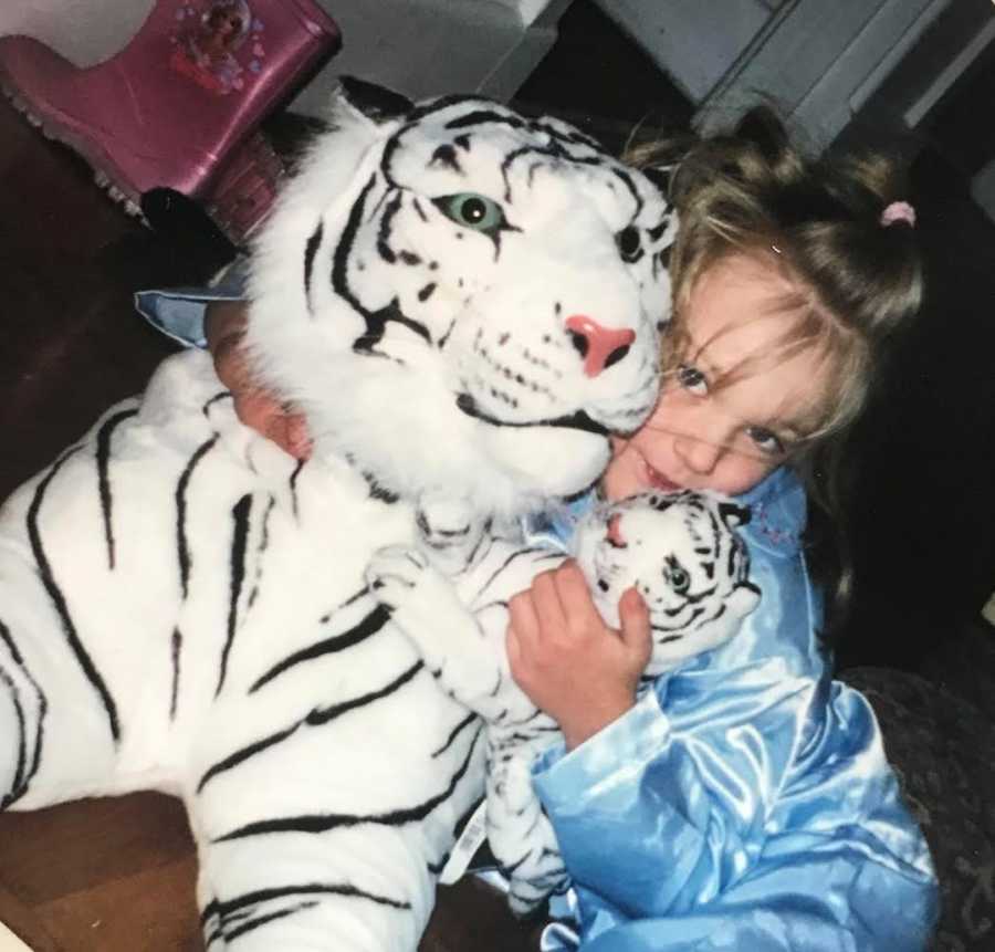 girl holding stuffed tiger