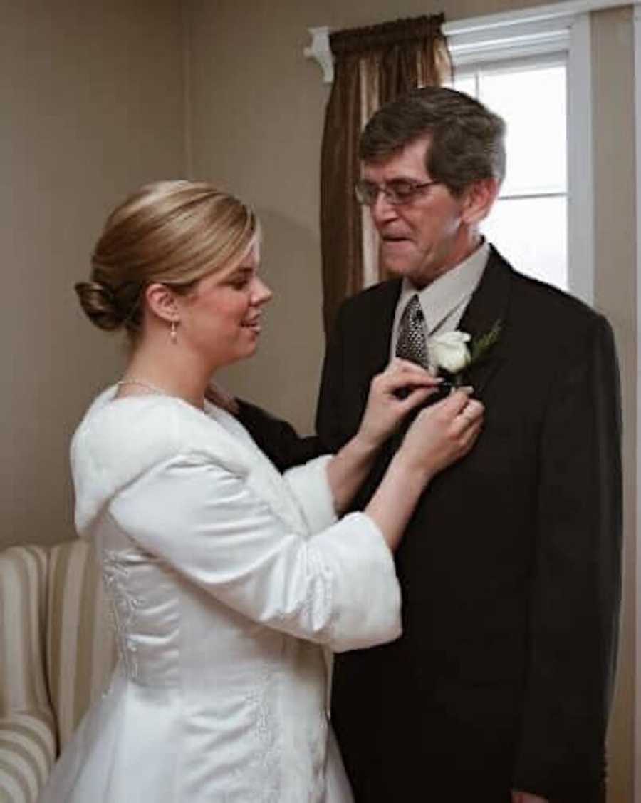 woman pinning a flower on dad's suit