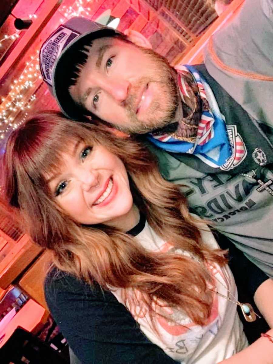 Couple smile and take a selfie together as they wait for their food at Applebee's