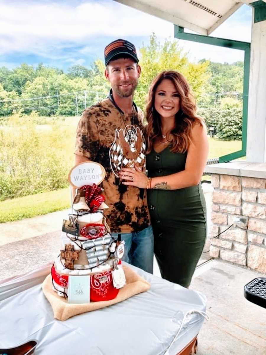 Newly engaged couple take a photo at their baby shower