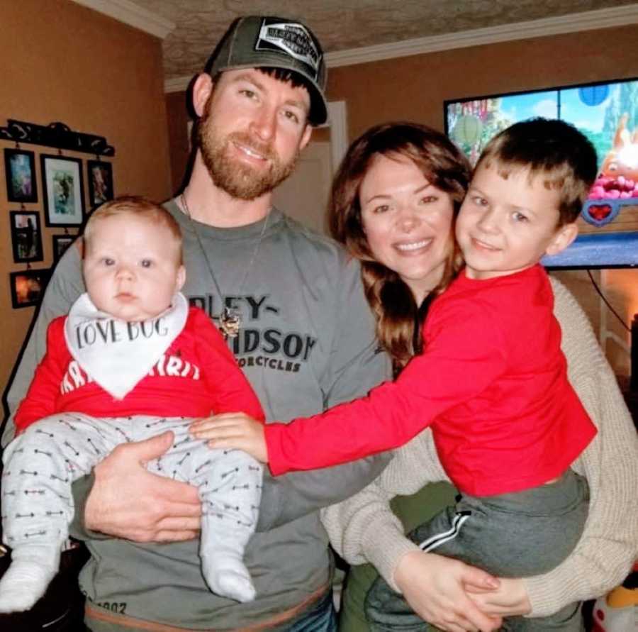 Couple take family photo in their living room with their two sons