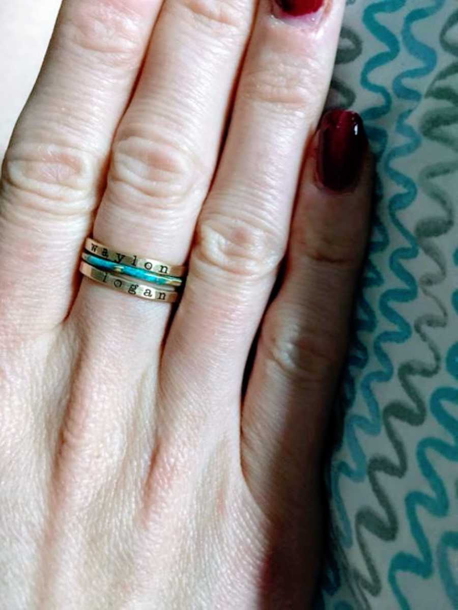 Woman shows off her new stackable rings that have her sons' names engraved on them