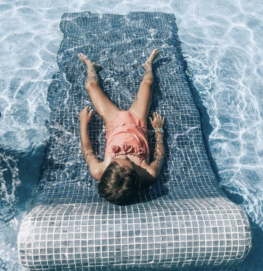 Child laying in pool